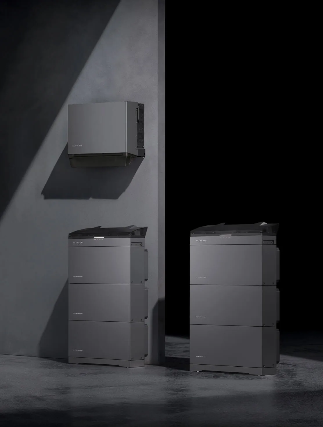 Inversor PowerOcean Plus fixado na parede e duas torres de baterias em estúdio escuro